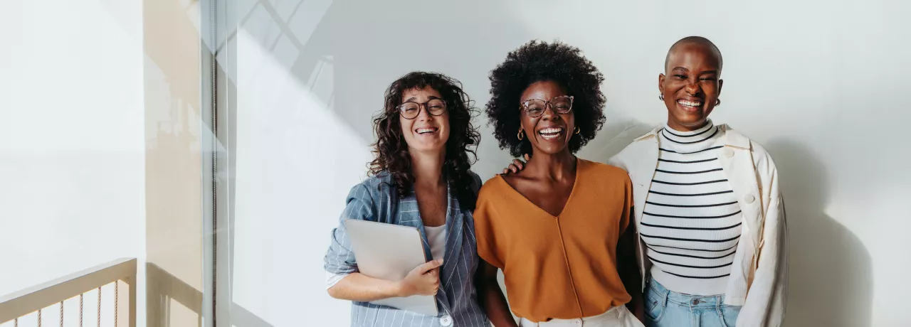 three employees smiling at the camera