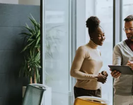 A group of employees working collaboratively together on an tablet.