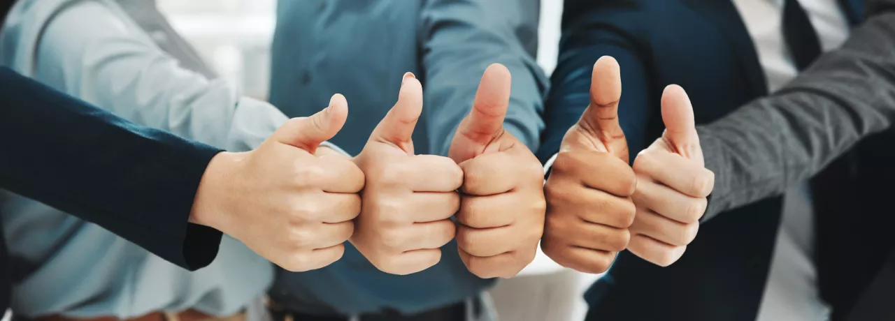 Five people giving a thumbs up