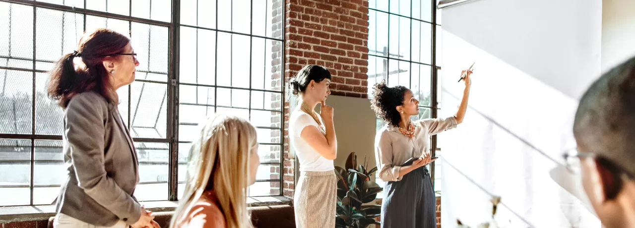 A group of colleagues brainstorming at a white board